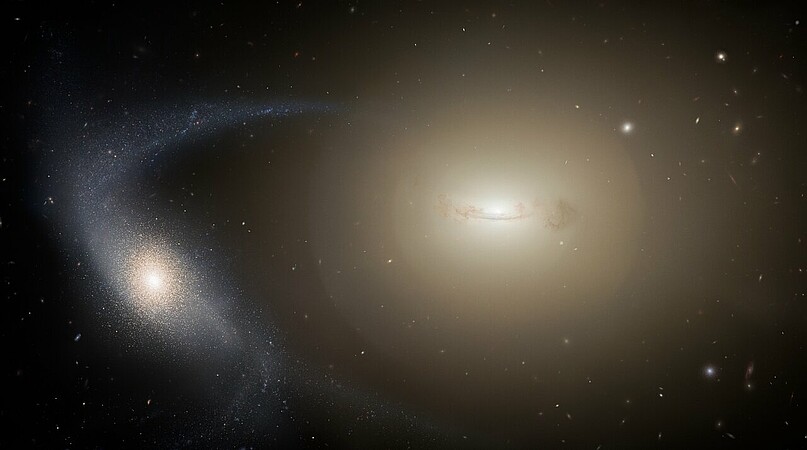 Vue d’artiste d’une galaxie naine (avant-plan à gauche) se faisant dépouiller de ses étoiles par interaction gravitationnelle avec une galaxie massive (à droite en arrière-plan). © NOIRLab/NSF/AURA/M. Zamani