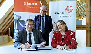 Didier Samuel et Frédérique Berrod signent la convention, sous le regard de Claudio Galderisi, recteur délégué à l’Enseignement supérieur, à la Recherche et à l’Innovation de la Région Grand Est. © Catherine Schröder/Unistra