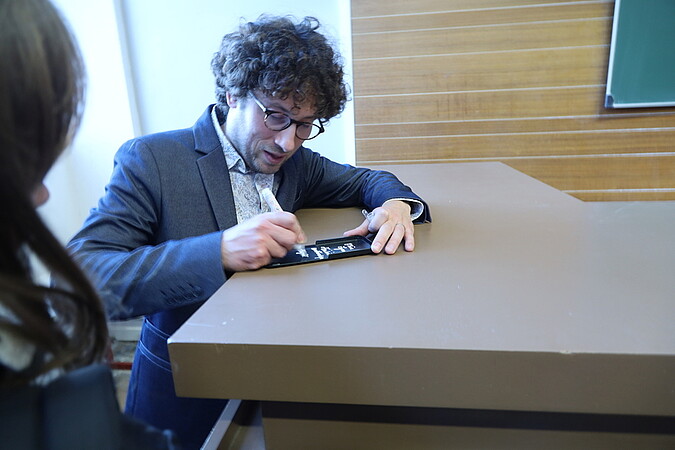 A l'issue de la conférence, Hugo Duminil-Copin signe des autographes, pour certains sur des calculatrices ! © Catherine Schröder / Unistra
