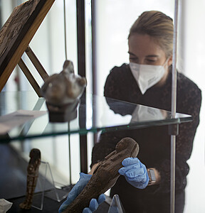 Cassandre Hartenstein, la commissaire de l’exposition, replace une statuette dans une vitrine.